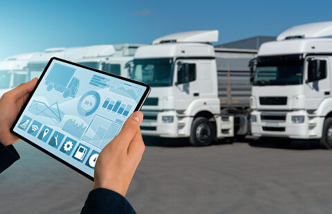 Manager with a digital tablet on the background of trucks. Fleet management